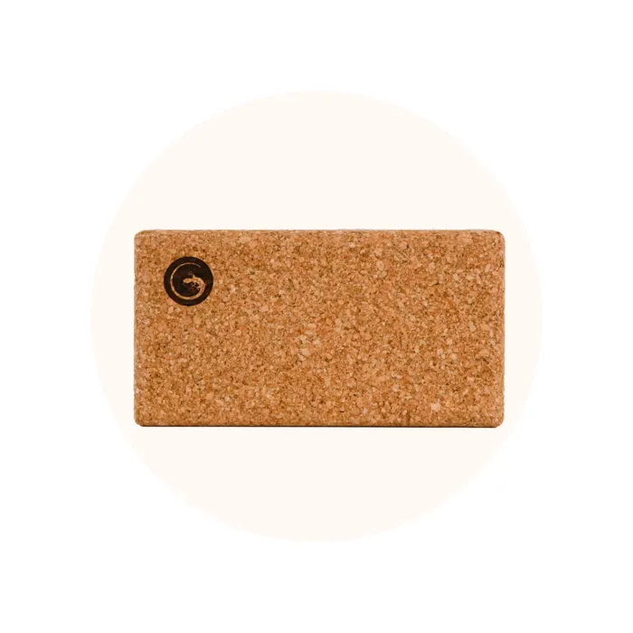 Cork yoga block standing on a plain background