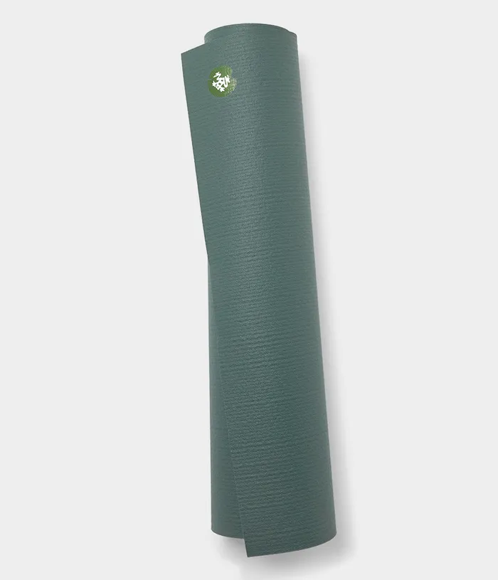 Sage green yoga mat rolled and standing on a light background
